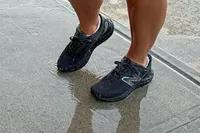 A person walks on concrete while wearing the New Balance Women's Fresh Foam Arishi v4 GTX Running Shoes