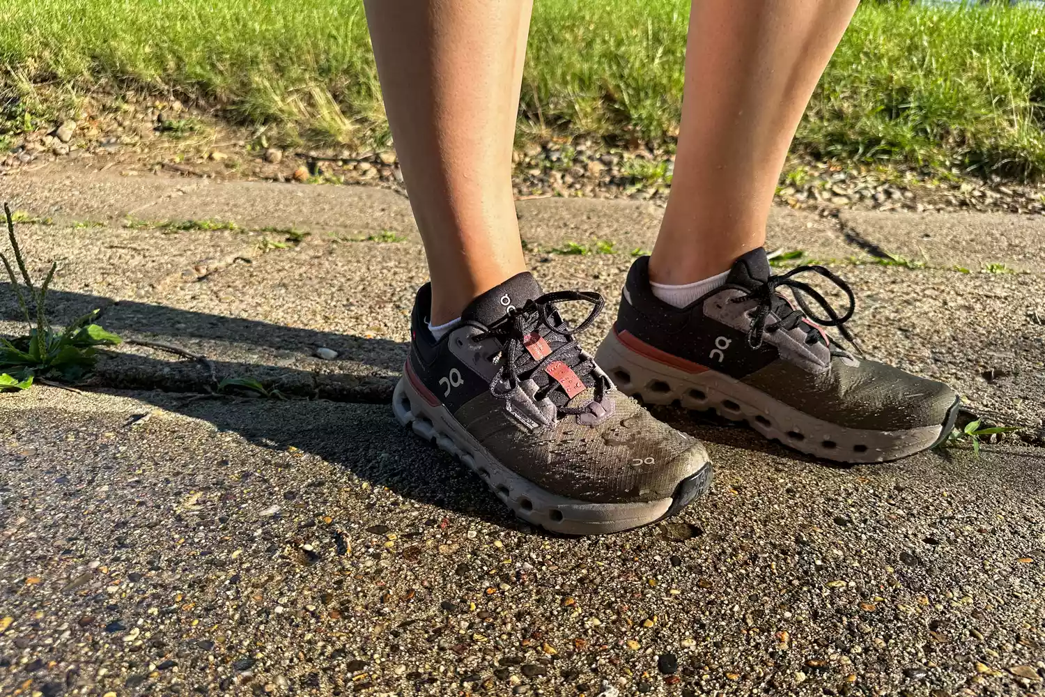 A person stands on concrete while wearing the On Women's Cloudrunner 2 Running Shoes