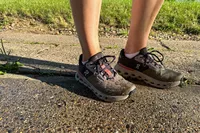 A person stands on concrete while wearing the On Women's Cloudrunner 2 Running Shoes