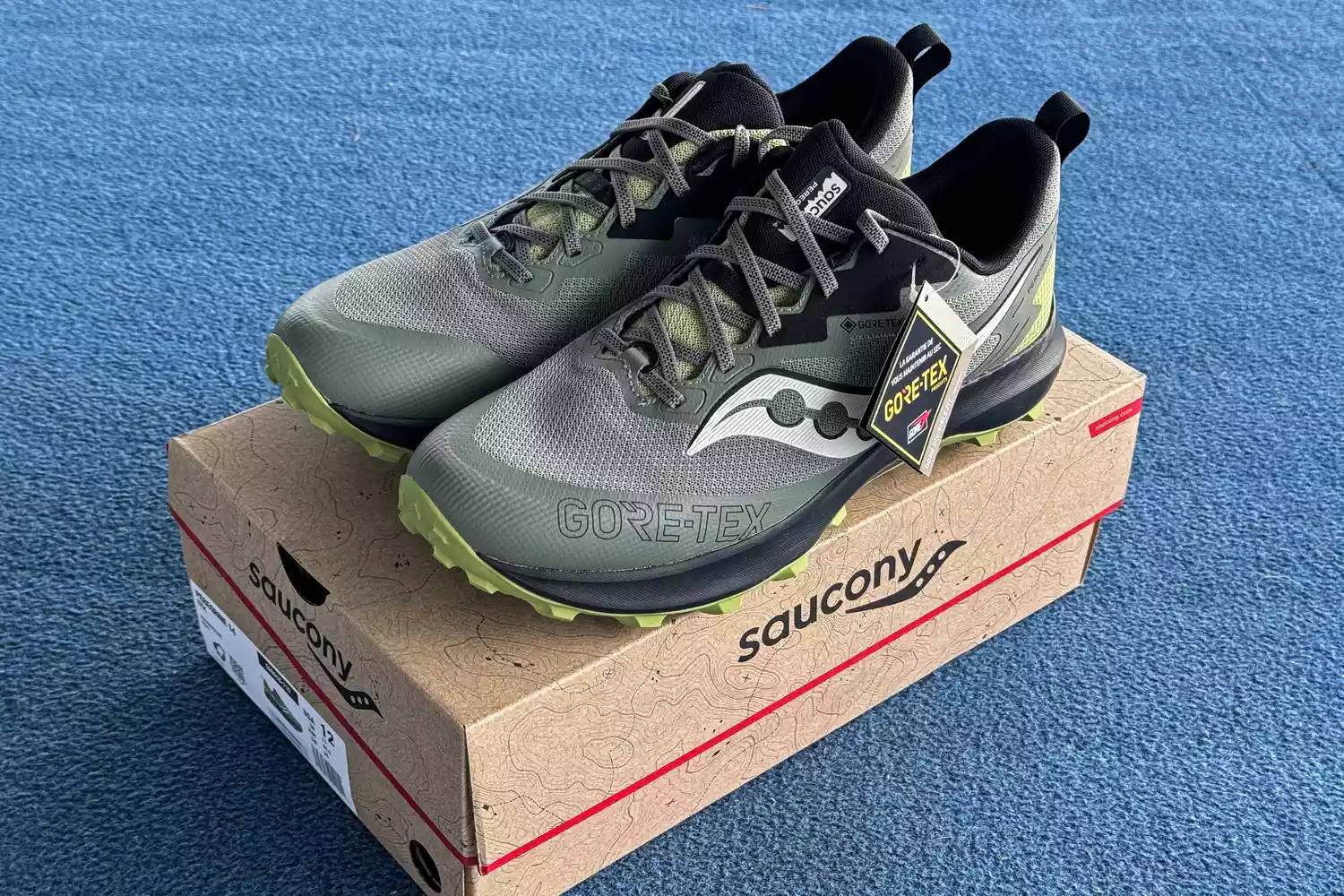 A pair of Saucony Men's Peregrine 14 GTX Waterproof Running Shoes on a shoebox