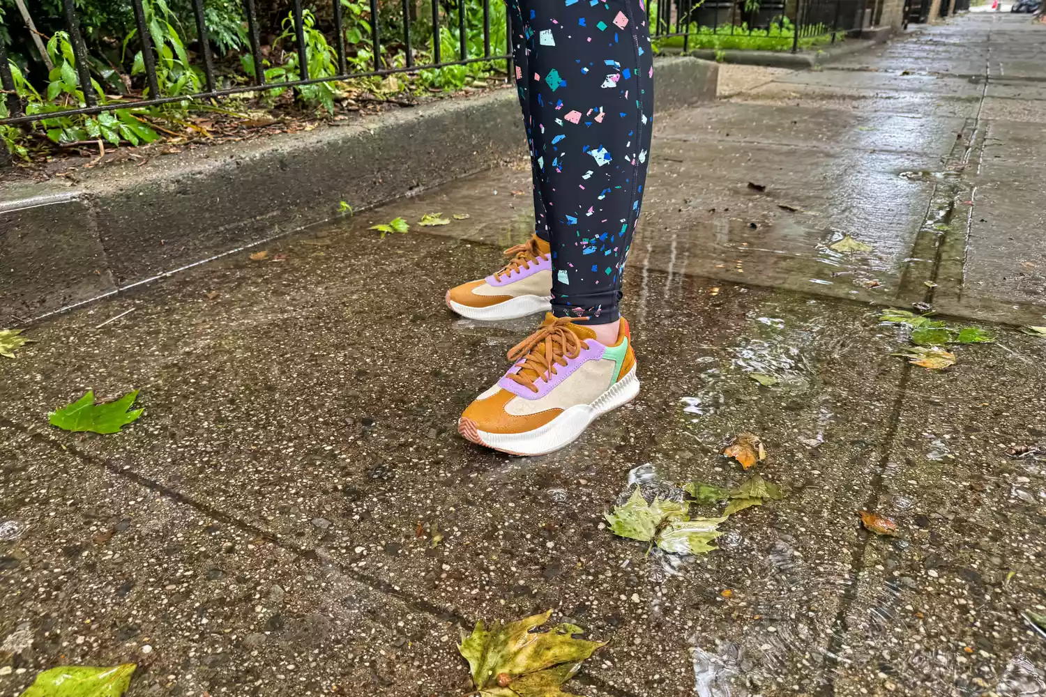 A person stands outside while wearing the Sorel ONA Blvd Classic Womenâs Waterproof Sneakers