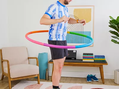 A person exercises using the Fiteroc Weighted Fitness Hula Hoop