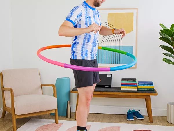 A person exercises using the Fiteroc Weighted Fitness Hula Hoop