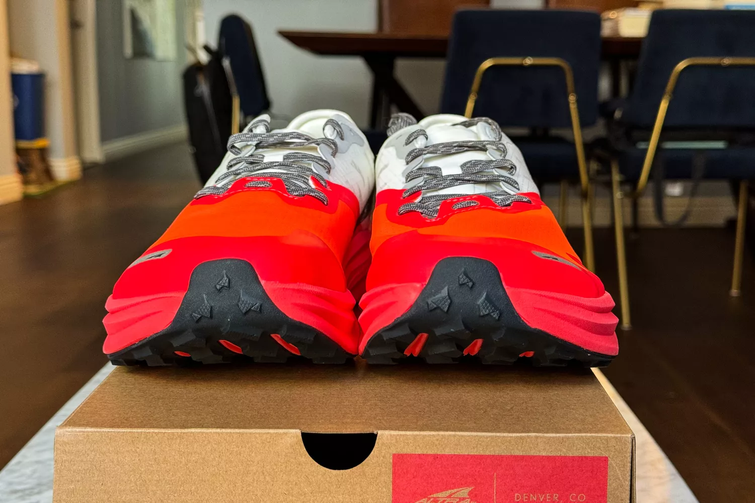 A pair of Altra Running Mont Blanc Carbon Menâs Trail Running Shoes on top of their box in dining room setting