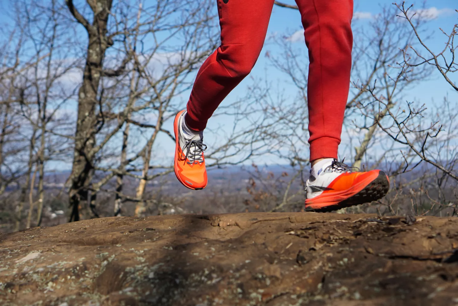 A close-up of a person's legs running on dirt while wearing the Altra Running Mont Blanc Carbon Menâs Trail Running Shoes