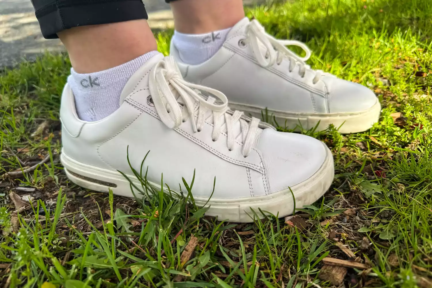 A close-up of the Birkenstock Bend Low Leather Sneakers worn in grass