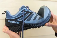 Two hands bending the Inov8 Menâs TrailFly
