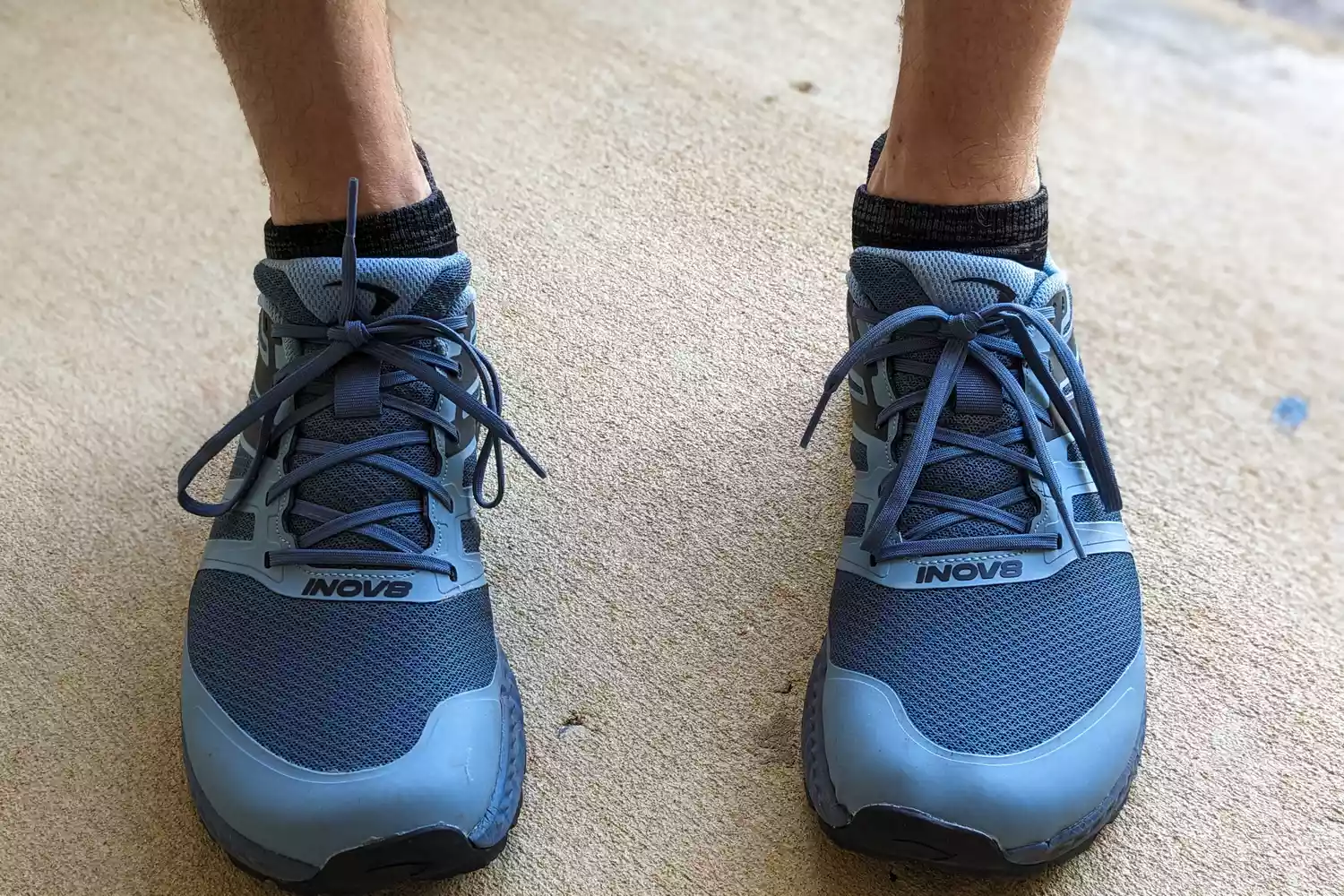 A close-up of Inov8 Menâs TrailFly on a person's feet