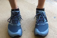 A close-up of Inov8 Menâs TrailFly on a person's feet