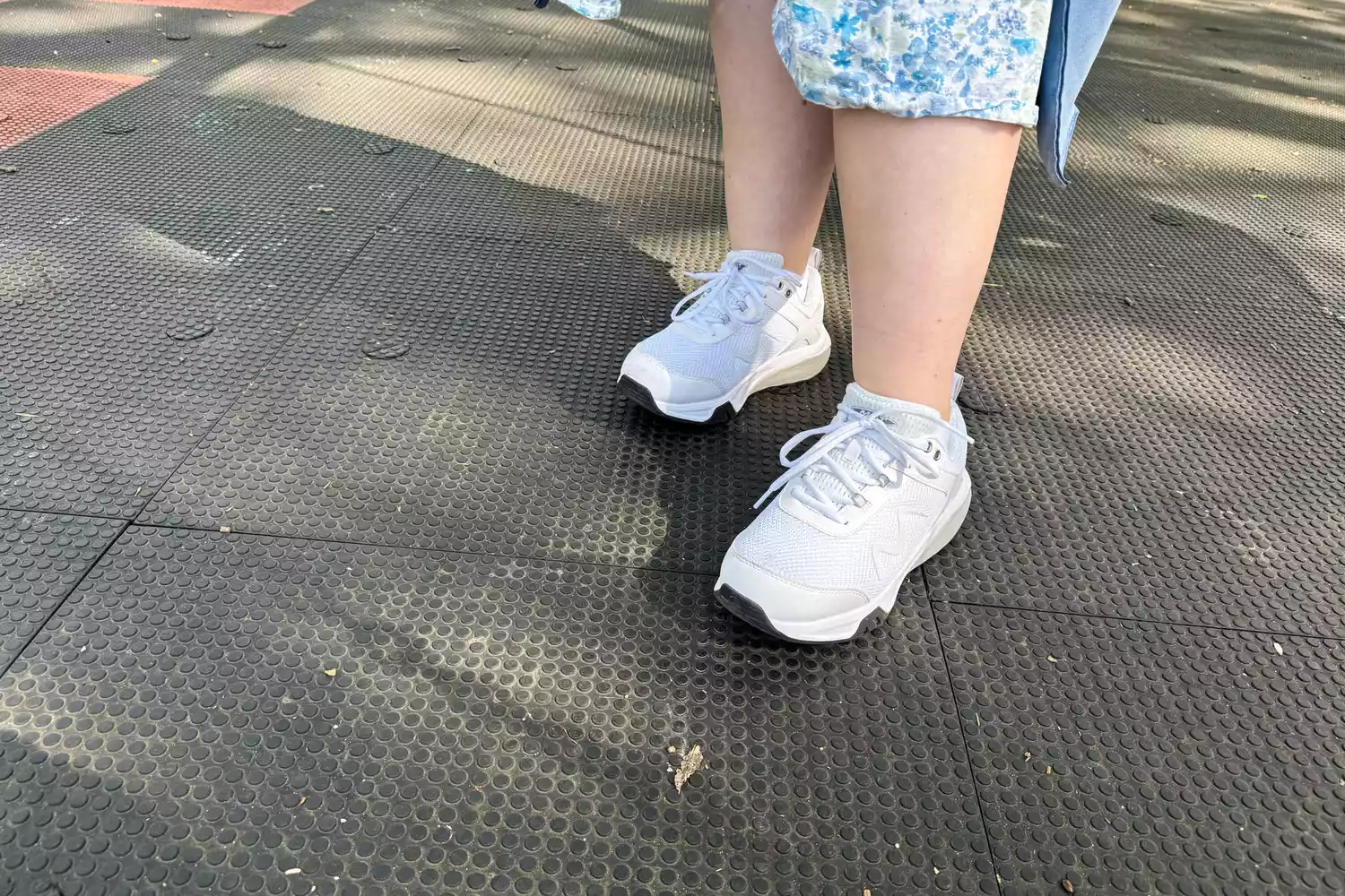A person wearing MBT Womenâs Sport 4 II on a black textured background