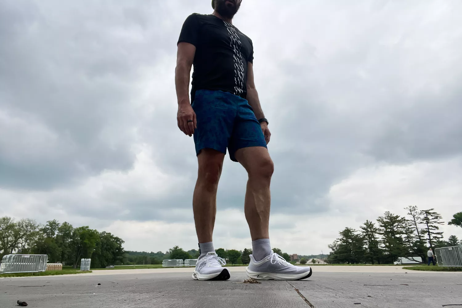 A person standing outside while wearing Topo Athletic Men's Cyclone 2 shoes