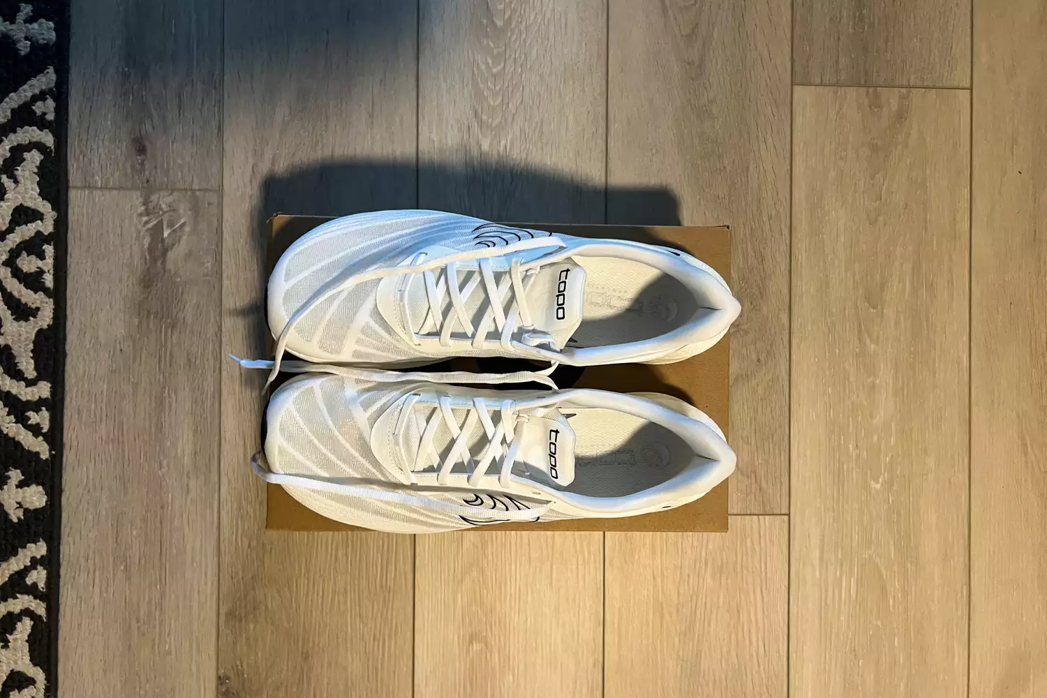 A top-angle view of the Topo Athletic Men's Cyclone 2 sneakers on top of their box