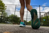 The back of the Topo Athletic Womenâs Ultrafly 5 sneakers worn at a park