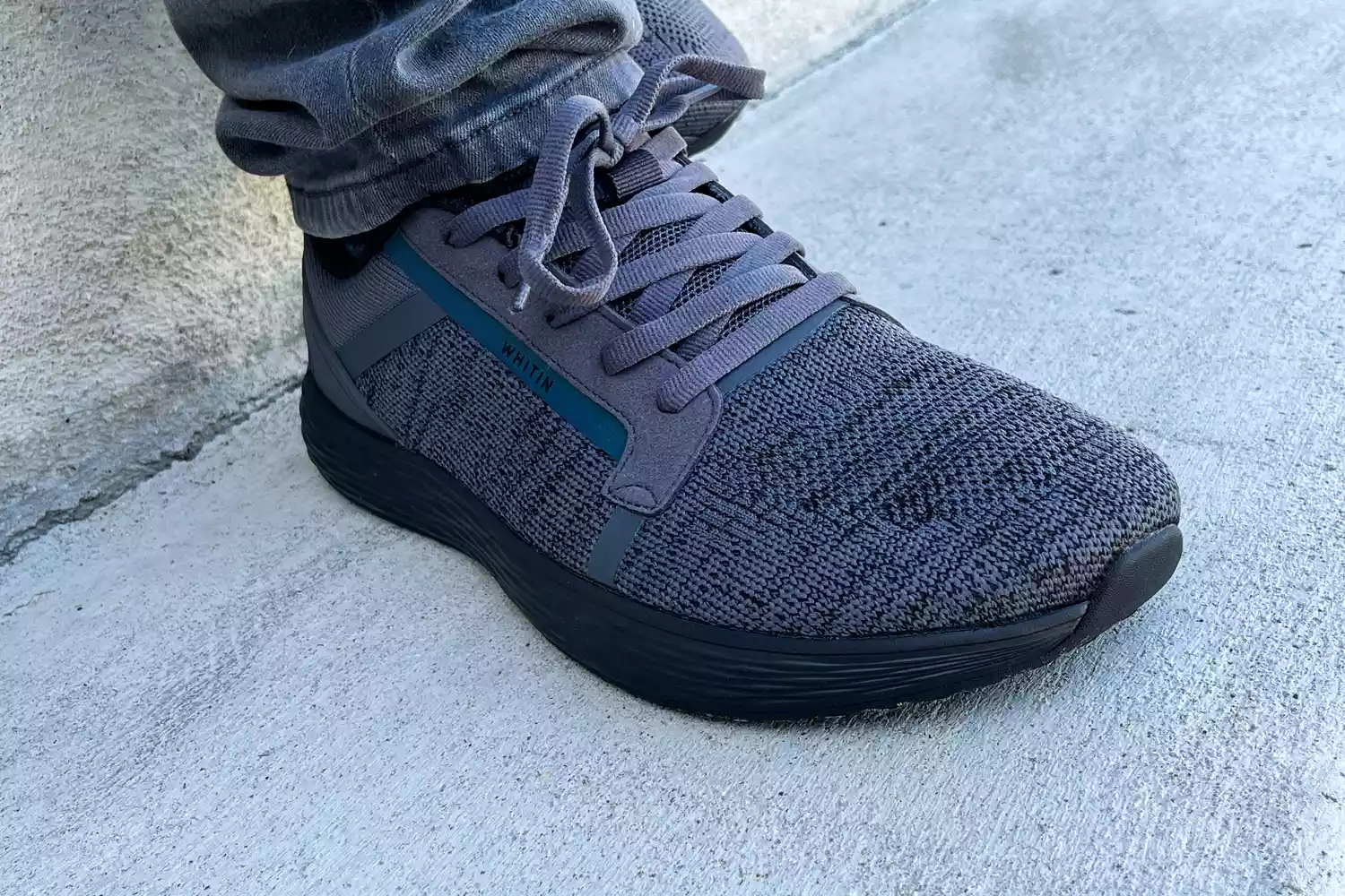 A close-up of the WHITIN Men's Wide Toe Box + Zero Drop Sole Road Running Shoe on concrete