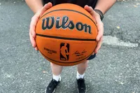 A person holds the Wilson NBA Authentic Outdoor Basketball