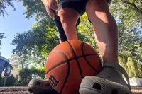 A person pumps up the Wilson NBA Authentic Outdoor Basketball