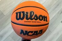 A person holds up the Wilson NCAA Evo NXT Game Basketball