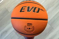 A person holds the Wilson NCAA Evo NXT Game Basketball