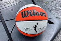 The Wilson WNBA Authentic Outdoor Basketball on the base of a basketball hoop