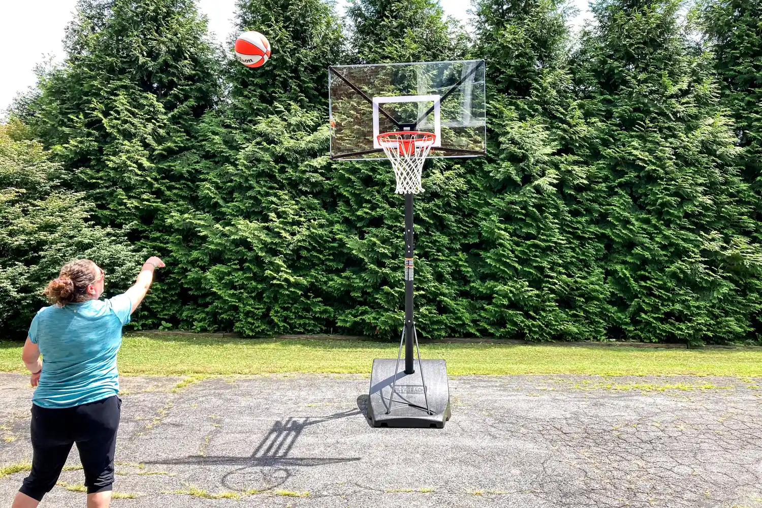 A person shoots the Wilson WNBA Authentic Outdoor Basketball