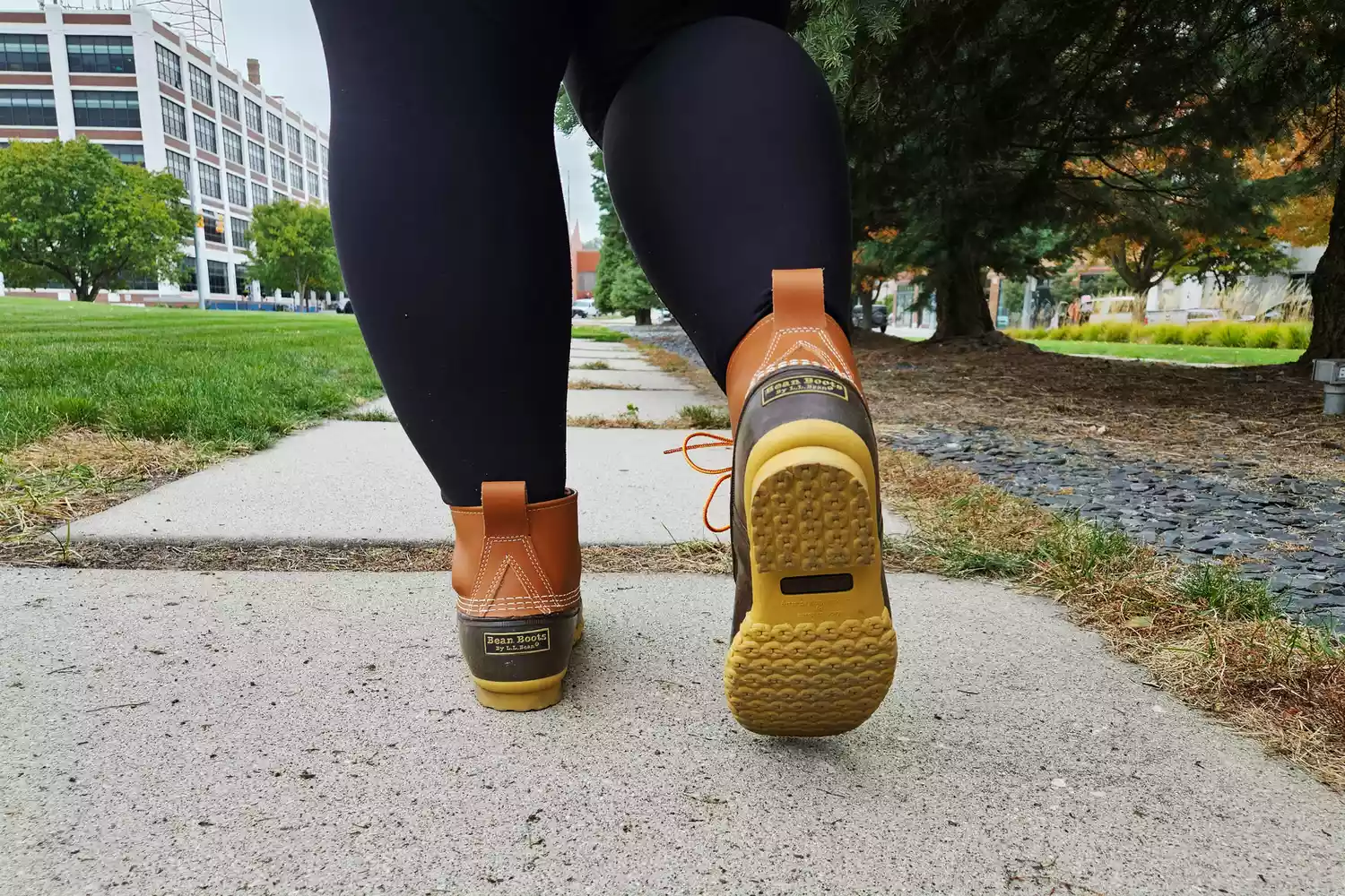 A person walks while wearing the L.L. Bean Women's 6in Bean Boots