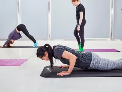 A woman does a plank pose on a Nike Training Mat 2.0