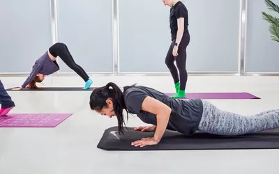 A woman does a plank pose on a Nike Training Mat 2.0