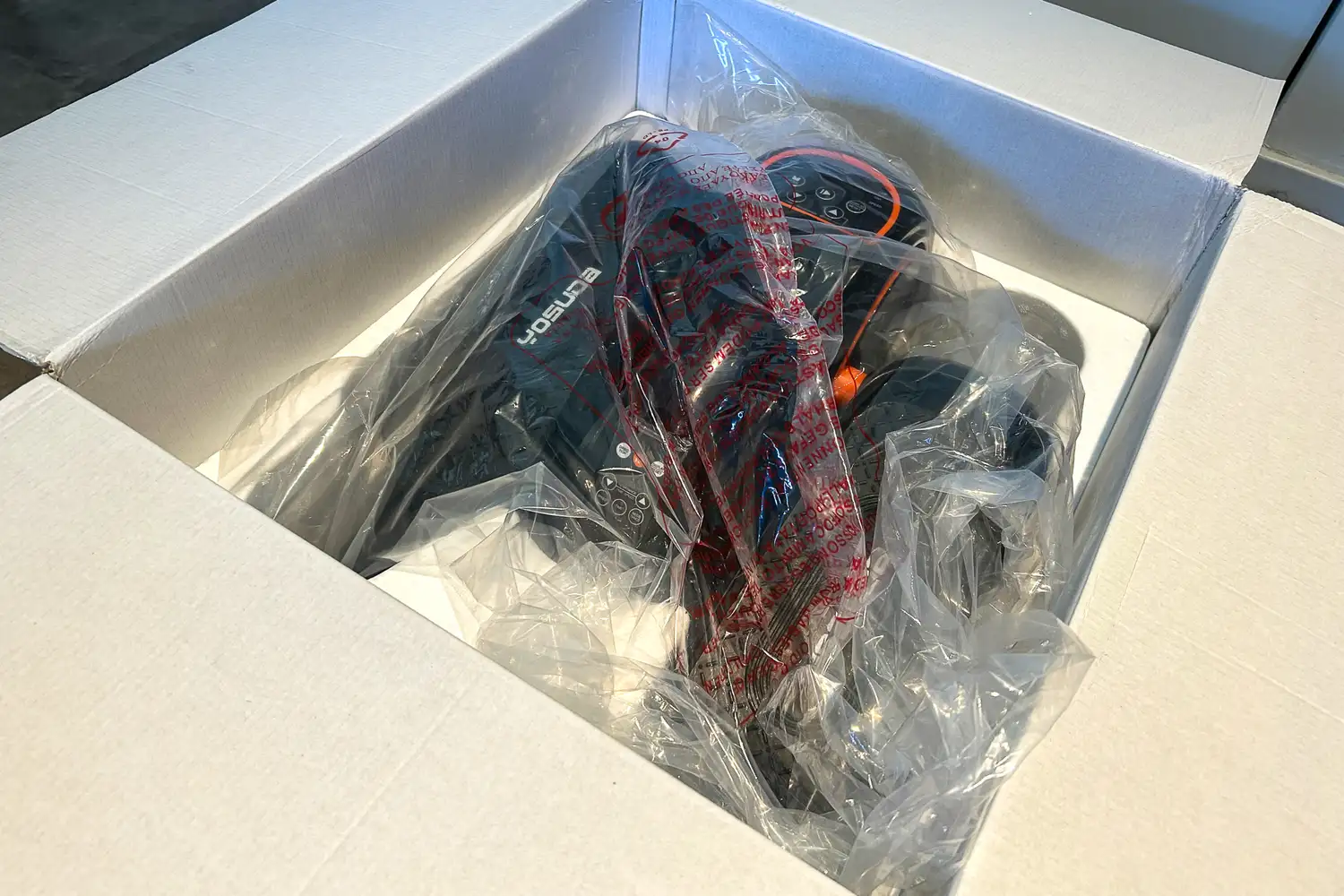 The pieces of the YOSUDA E5 Under Desk Elliptical Machine in plastic packaging