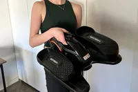 A person lifts the YOSUDA E5 Under Desk Elliptical Machine