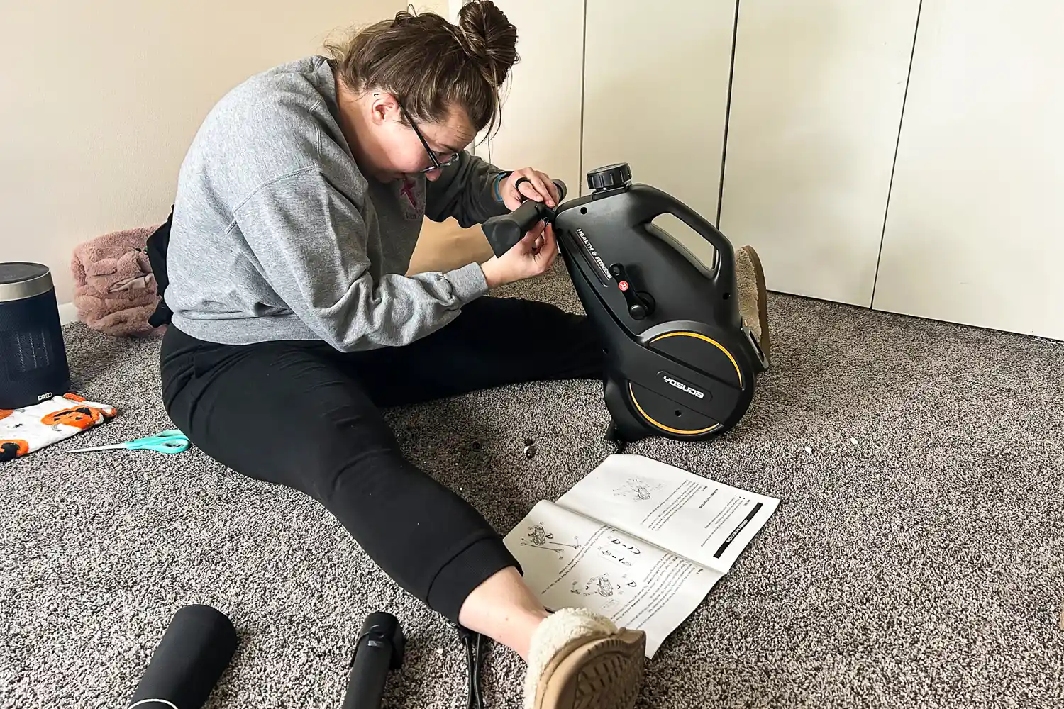 A person assembles the YOSUDA YBM-2 Under Desk Bike Pedal Exerciser