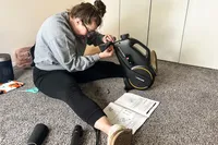 A person assembles the YOSUDA YBM-2 Under Desk Bike Pedal Exerciser