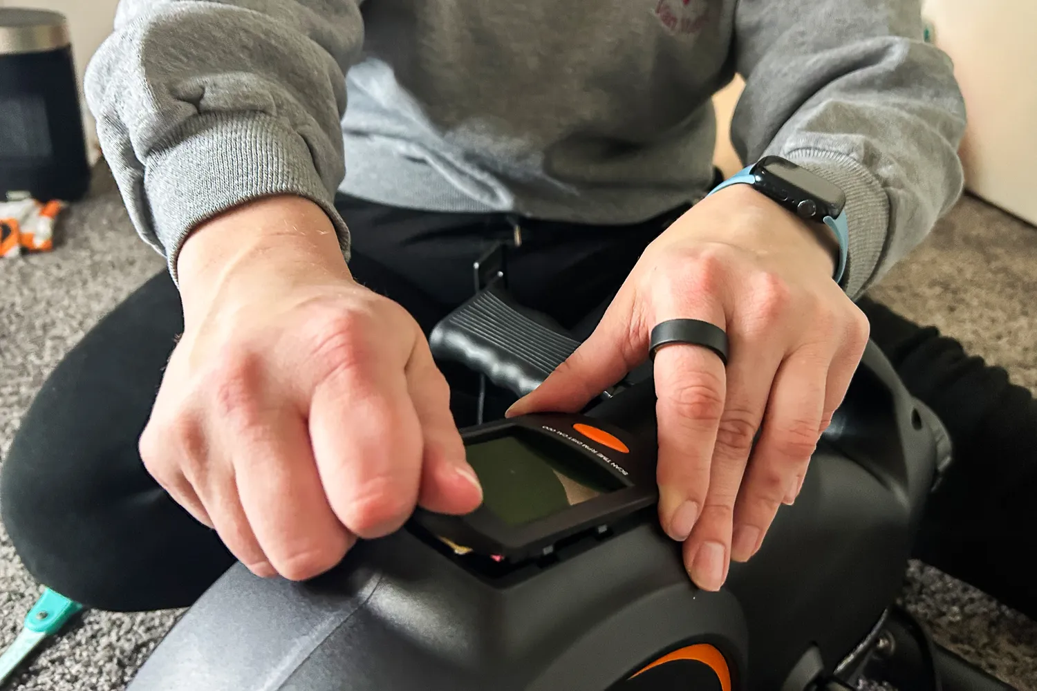 A person adjusts the YOSUDA YBM-2 Under Desk Bike Pedal Exerciser