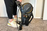 A person lifts the back of the YOSUDA YBM-2 Under Desk Bike Pedal Exerciser