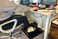 A person pedals on the YOSUDA YBM-2 Under Desk Bike Pedal Exerciser