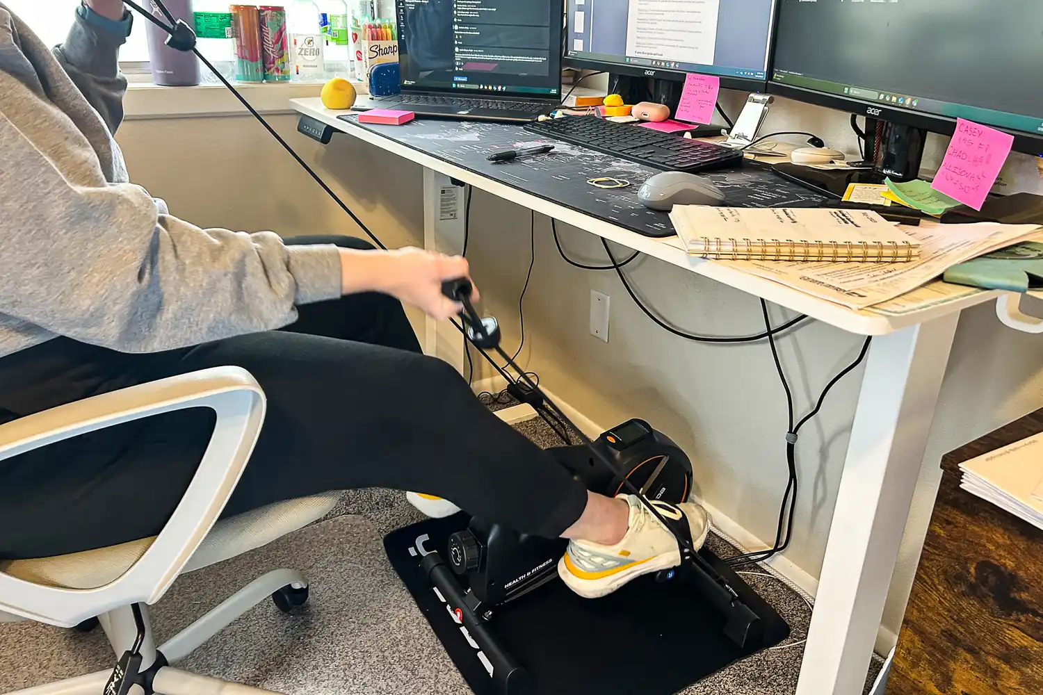 A person uses the arm bands on the YOSUDA YBM-2 Under Desk Bike Pedal Exerciser