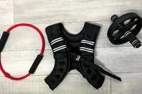 The Zelus Weighted Vest on the ground next to a pilates ring