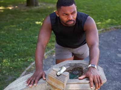 man leaning over drinking fountain feeling nauseated