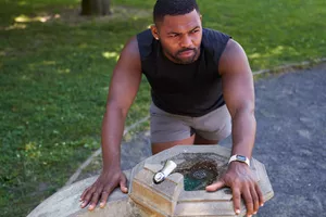 man leaning over drinking fountain feeling nauseated