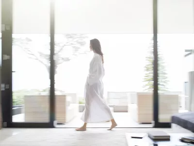 Woman in bathrobe walking through living room