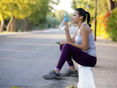 Woman runner resting on a curb