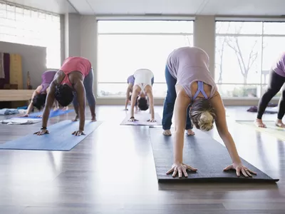 Women in a yoga class in downward facing dog position