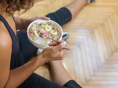 Young woman eating a oatmeal after a workout